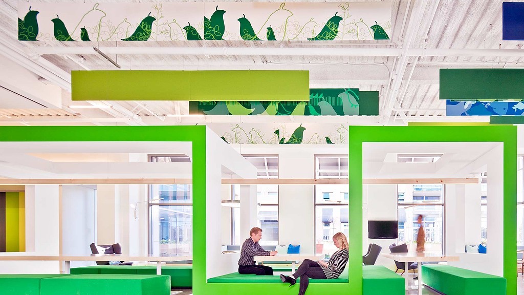 A couple of people sitting at a table in a room with green walls.