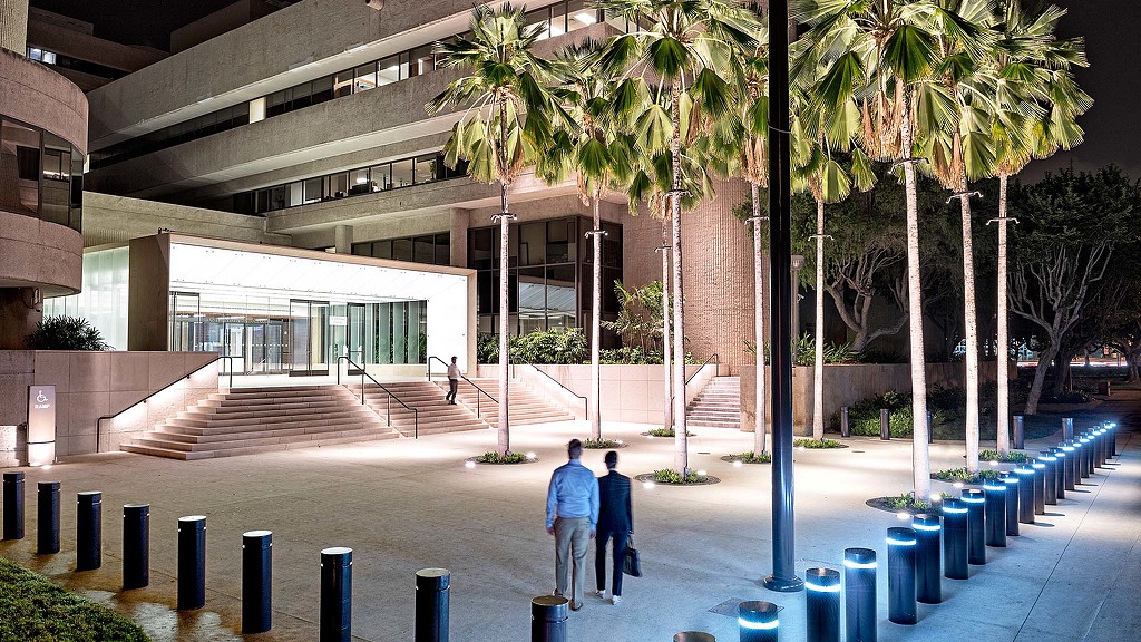 A building with palm trees and people walking around.