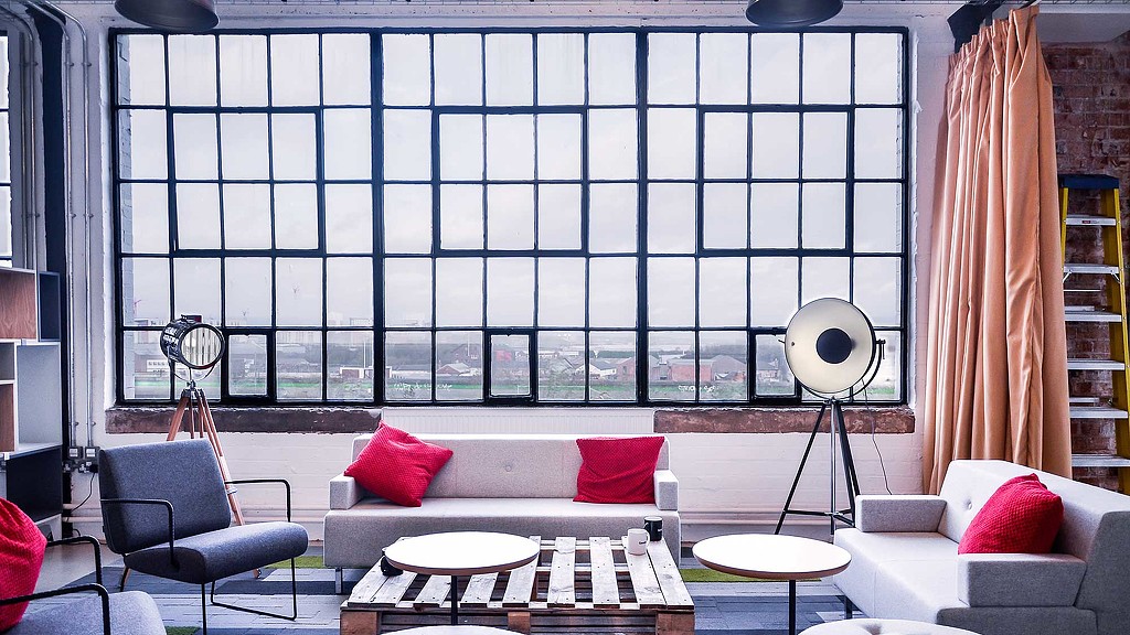 A room with a couch and chairs.