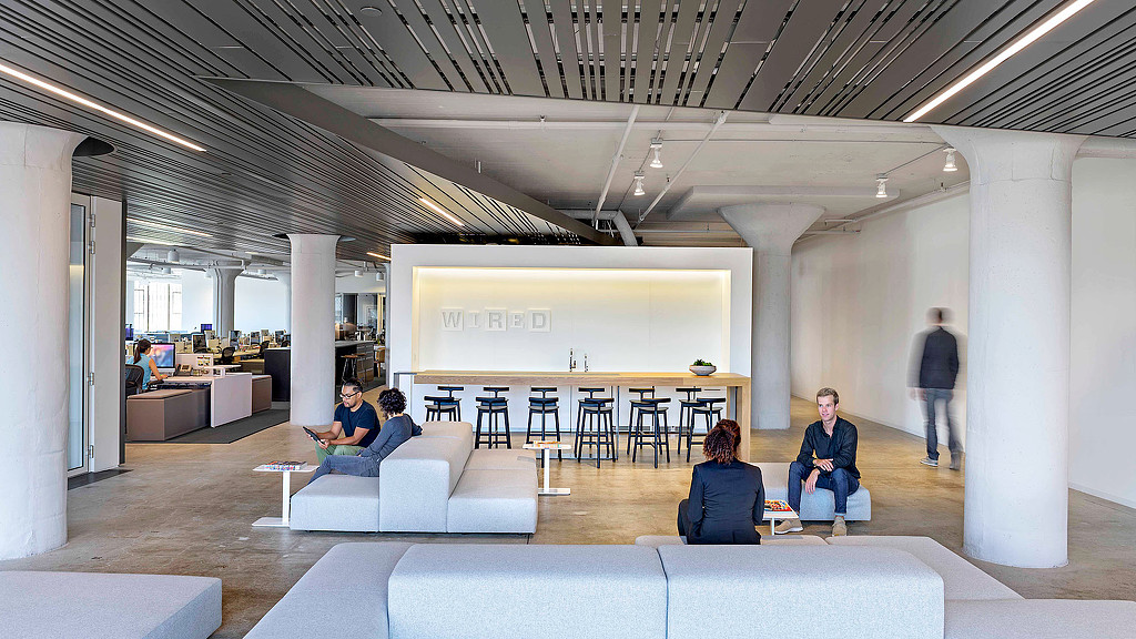 A group of people sitting in a room with white walls.