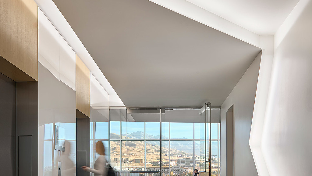 A room with a view of the water and a city.