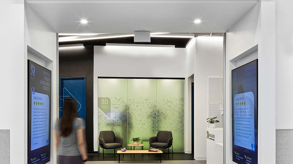 A woman walking into Reach Movement Studio.