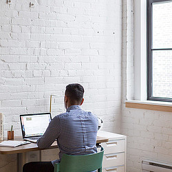 A person sitting at a desk with a laptop.