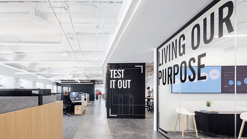 A large room with a sign and people in it.