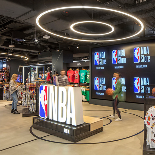 NBA Store Berlin interior with NBA sign and digital screen.