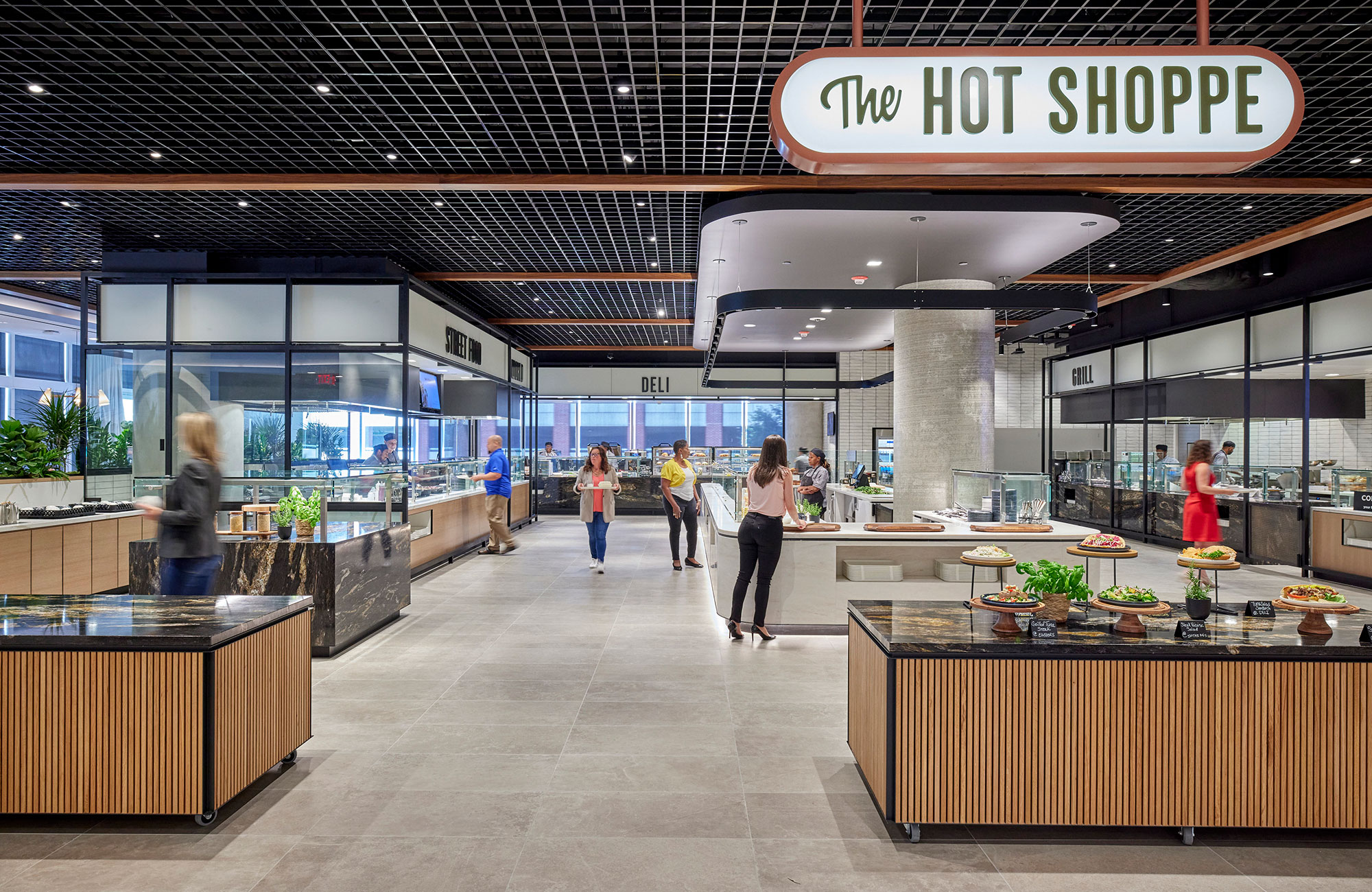 People walking in a large work cafeteria.