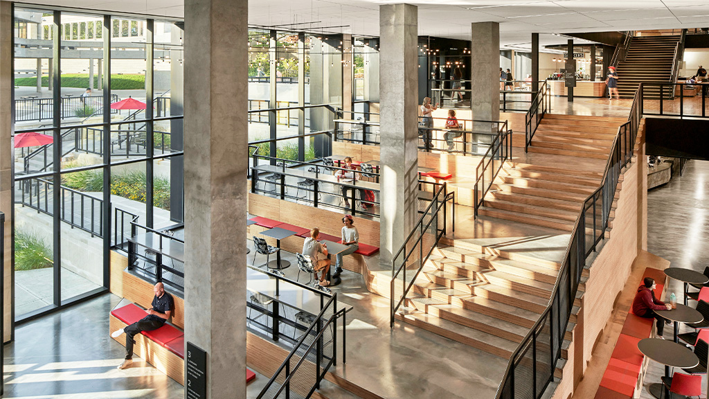 A modern wooden staircase with seating across multiple levels at Kentucky University Commons Helm Library