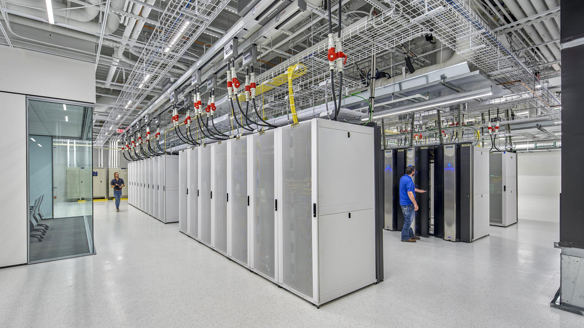 A person standing in a room with several large machines.