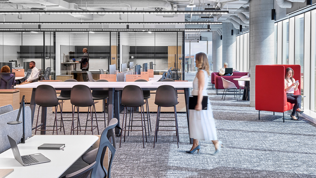 A person standing in a room with tables and chairs.